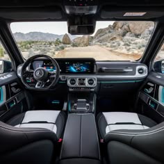 the interior of a vehicle with dashboards, steering wheel and dash lights in front of mountains