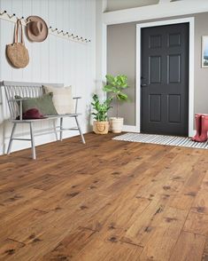 a wooden floor in a room with white walls and wood floors, two chairs on either side of the door