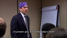 a man wearing a purple bandana standing in front of a whiteboard with words written on it