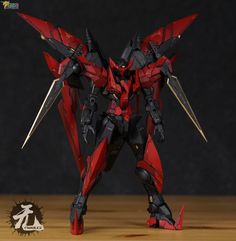 a red and black robot standing on top of a wooden table