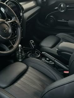 the interior of a car with black leather seats and steering wheel, including center console