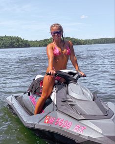 a woman sitting on top of a jet ski in the water