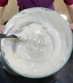 a person mixing white cream in a bowl