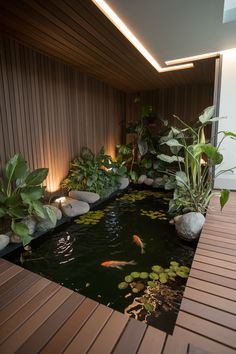 an indoor pond surrounded by plants and rocks