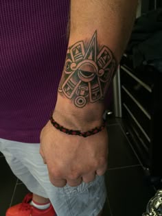 a man with a tattoo on his arm is holding the hand of another mans wrist