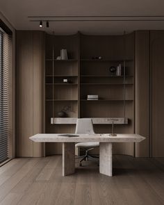 an office desk with a laptop on it in front of a bookcase and window