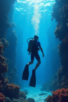a person diving in the ocean with scuba gear on and holding onto their equipment while standing under water