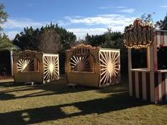 three carnival booths sitting in the middle of a field