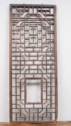 a wooden frame with an intricate design on the front and back sides, mounted against a white wall