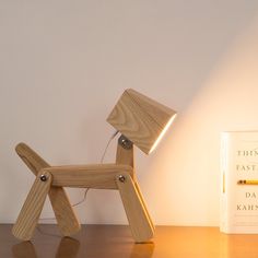 a wooden dog lamp sitting next to a book