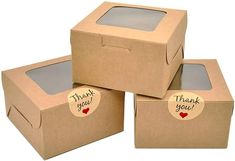 three cardboard boxes with thank you stickers on the lids and one has a window