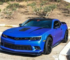 a blue chevrolet camaro is parked on the street