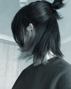 a woman with black hair is looking at her cell phone