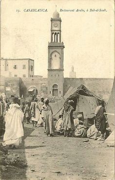 an old black and white photo of people in front of a clock tower