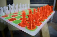 an orange and white plastic chess set on a table