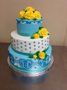 a three tiered cake with yellow roses on it's sides and blue icing