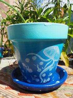 a blue flower pot sitting on top of a saucer