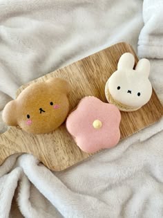 two cookies shaped like animals sitting on top of a wooden board next to each other