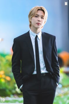 the young man is dressed in a suit and tie