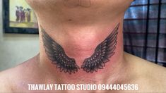 a man with a tattoo on his neck has an angel wing design on the back of his neck