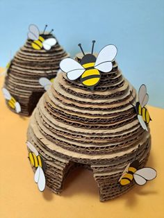 two beehive made out of cardboard sitting on top of a table