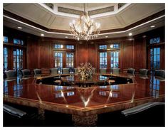 a large conference table with chairs and chandelier in the middle of a room