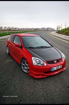 a red car is parked on the side of the road