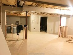 an empty room with unfinished walls and drywall in the middle, including clothes hanging on hooks