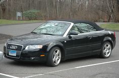 a black convertible car parked in a parking lot
