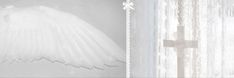 an angel wing hanging from the side of a window next to a curtain with white lace on it