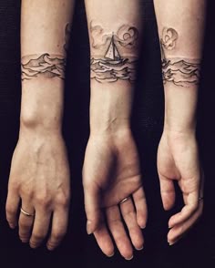 two people with matching tattoos on their arms and hands, both holding each other's hand