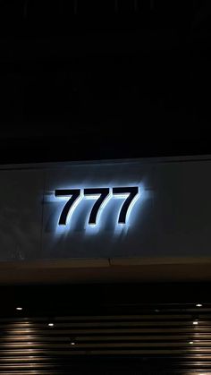 the sign for 777 is lit up at night