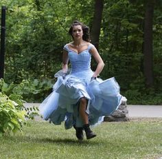 a woman in a blue dress is running through the grass