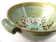 a green bowl sitting on top of a white table