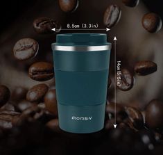 a blue coffee cup sitting on top of a pile of coffee beans