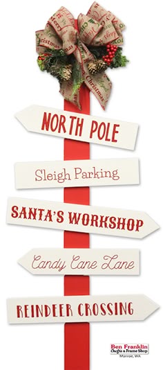 a red pole with white signs that say north pole sleigh parking santa's workshop candy cane lane and finder crossing