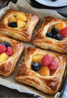 four pieces of pastry with fruit on top