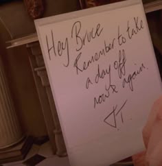a person holding up a sign that says hey bruce remembers to take a day off now again