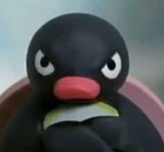 a close up of a toy penguin with big eyes