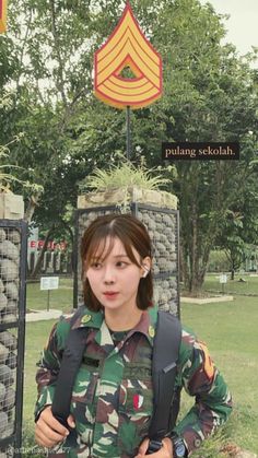a woman in uniform standing next to a sign