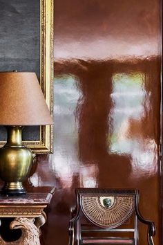 a chair and lamp in front of a painting