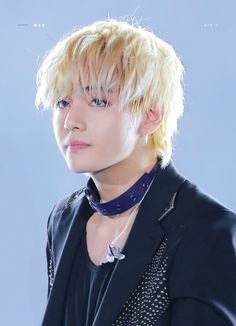 a man with blonde hair wearing a black jacket
