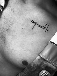 a man's chest with the word impossible written on it, in black and white