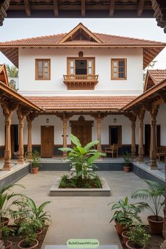 an outdoor courtyard with potted plants in front of the building and wooden pillars on either side