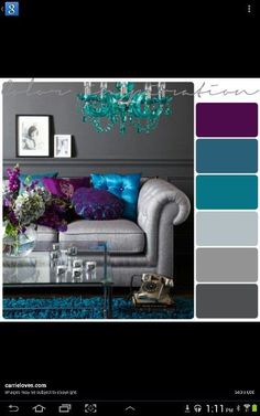a living room with purple and blue accents on the couch, coffee table and chandelier