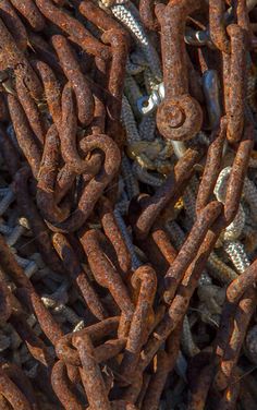many rusty chains are stacked together on the ground
