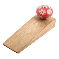 a red and white object sitting on top of a wooden board