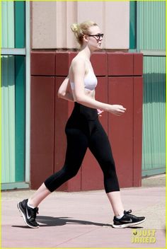 a woman in black leggings walking down the street