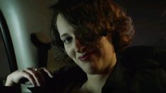 a woman sitting in the back seat of a car with her hand on her shoulder