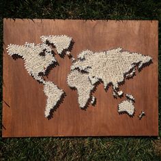 a piece of art made out of string and wood with the world map on it